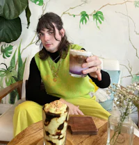 a man sitting on a chair holding a cup of coffee